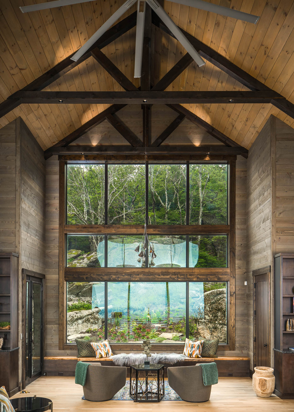 Cathedral ceiling and wall of windows overlooking the forest on the mountain ridge.