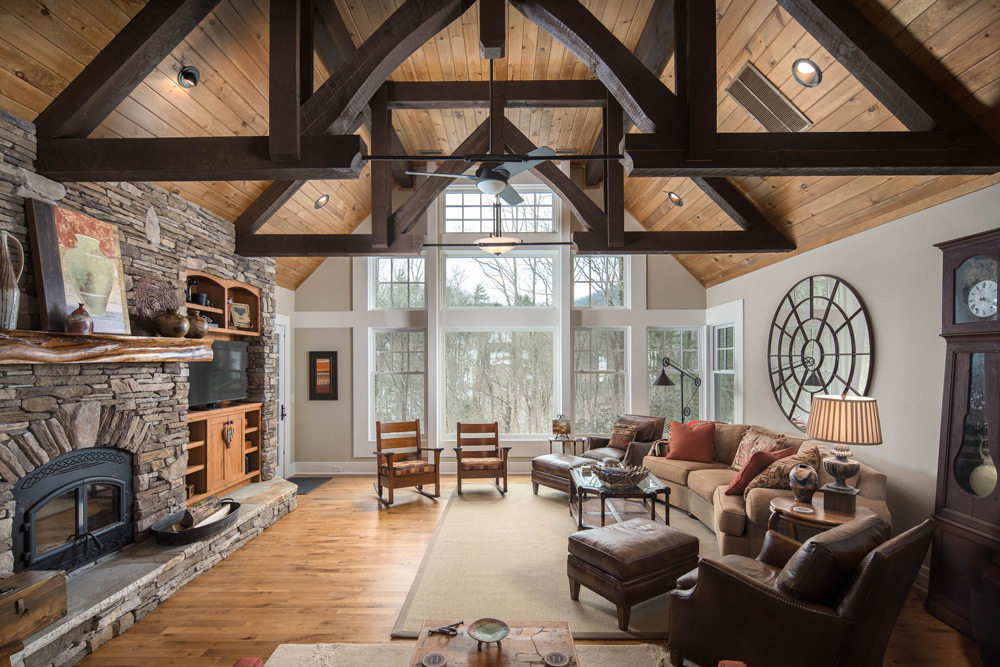Living room with cathedral ceilings, wood burning stove and large windows.