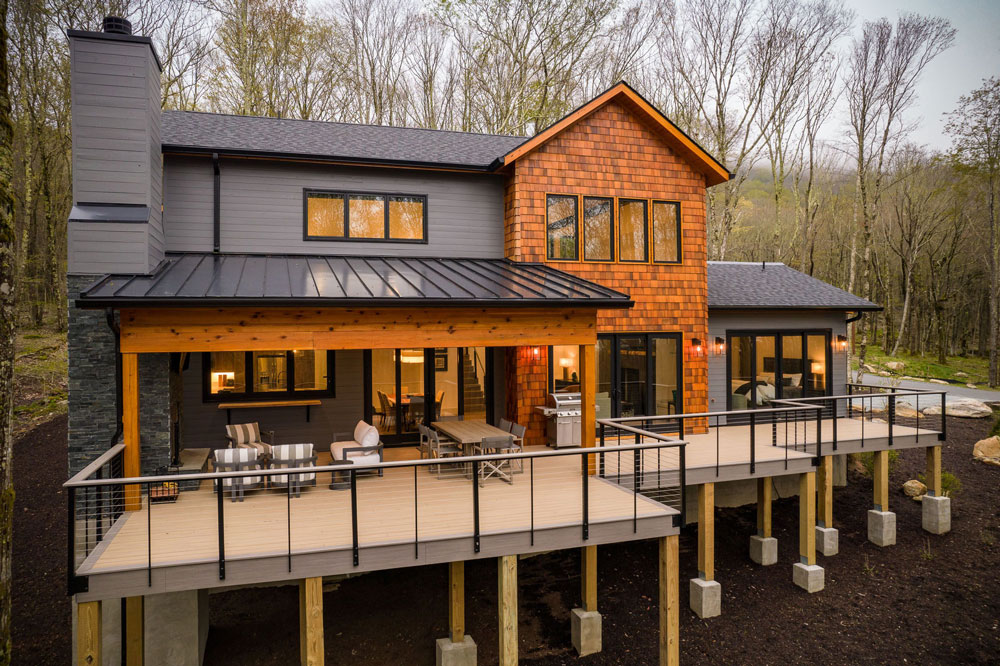 Exterior of home with patio and deck balcony built on a mountain.