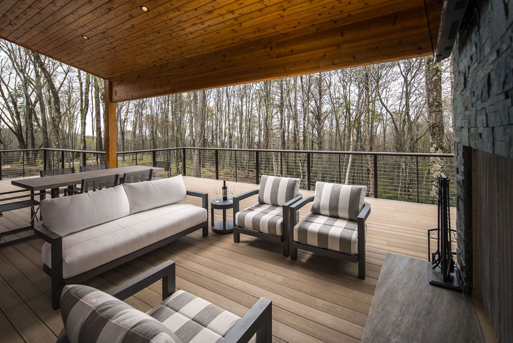 Exterior home expansion with custom deck and outdoor living space complete with fireplace.